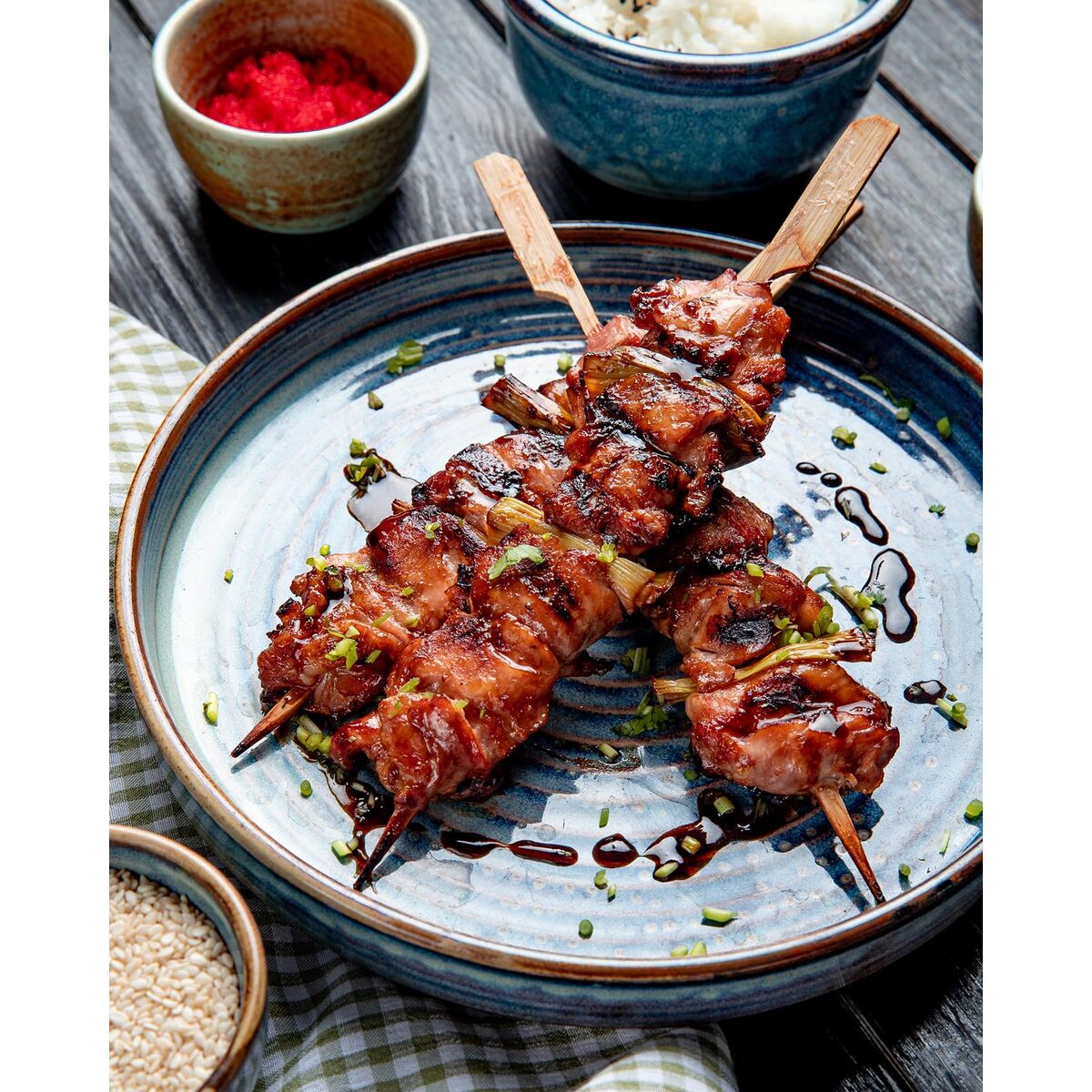 top view of grilled chicken skewers with soy sauce on a plate on wooden background S2238220_2